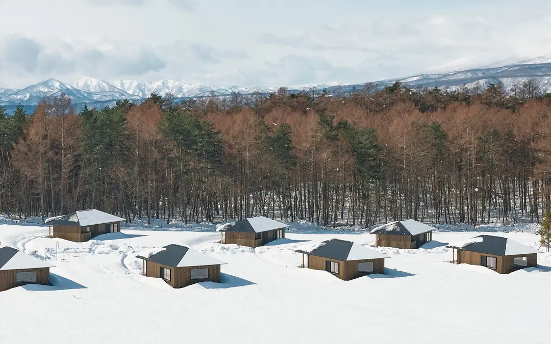 Wooden villas of AZUMA FARM Koiwai in a snow-covered pasture