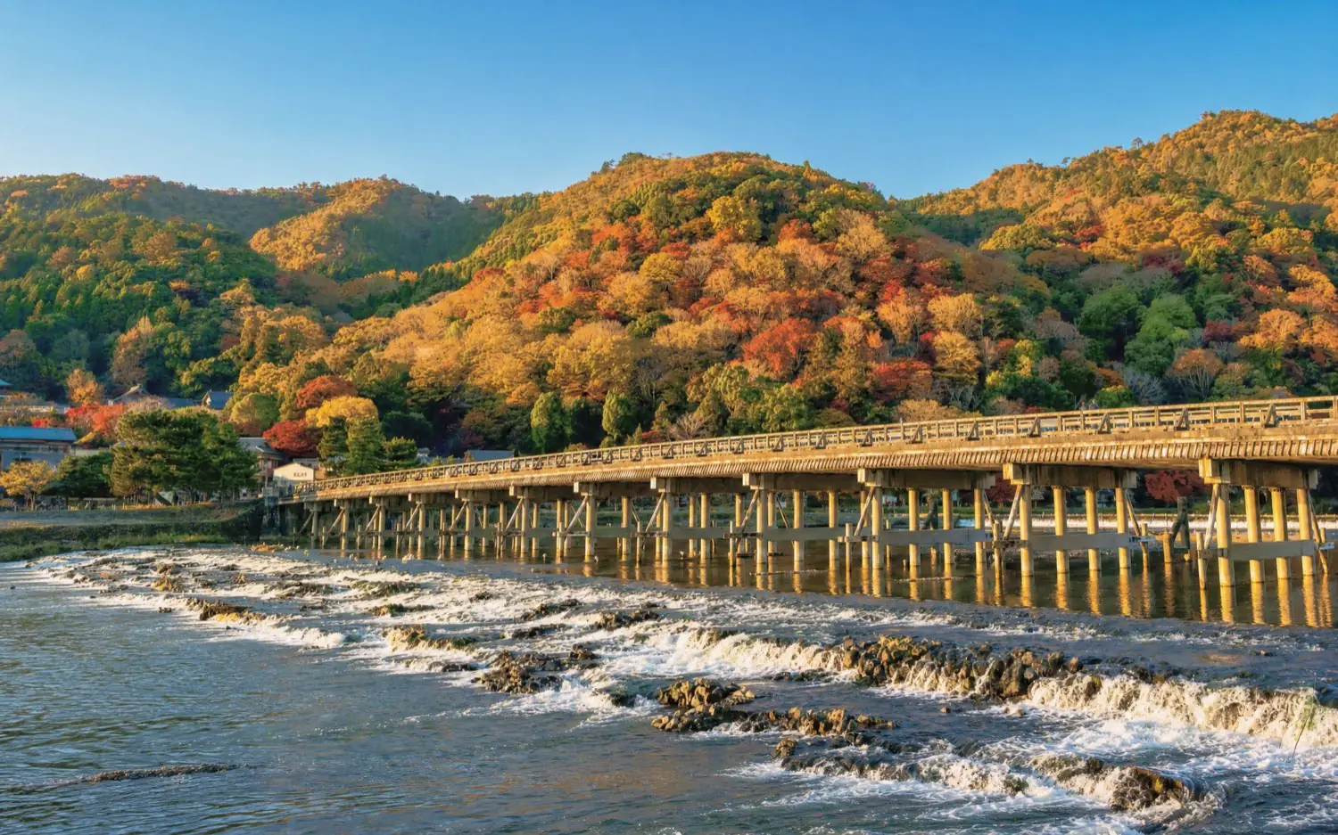 Togetsukyo Bridge with the autumn colours of Arashiyama behind it