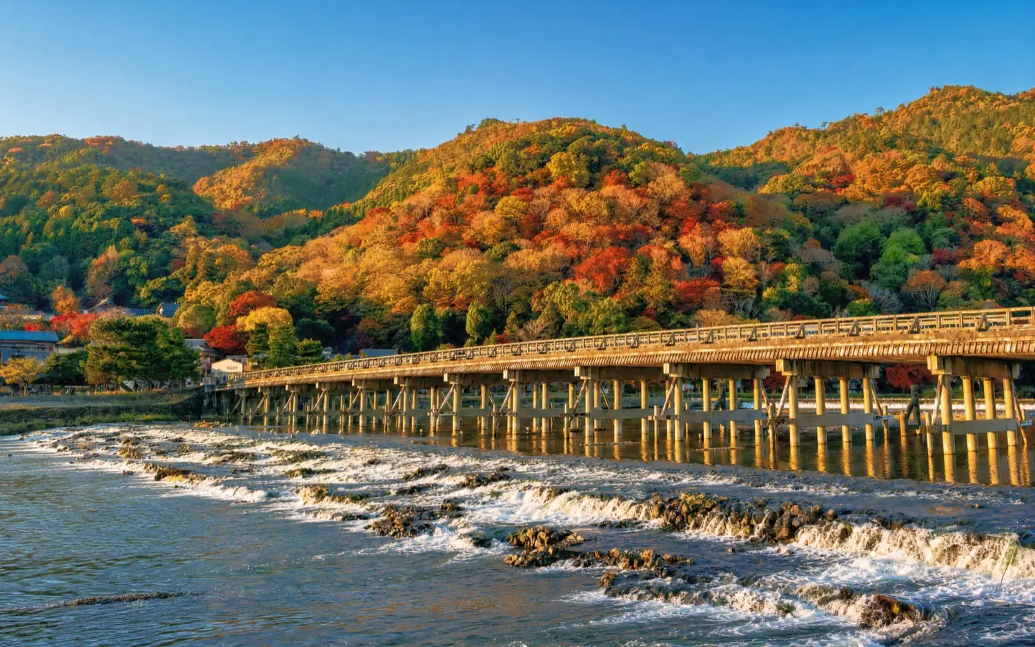 Togetsukyo Bridge with the autumn colours of Arashiyama behind it