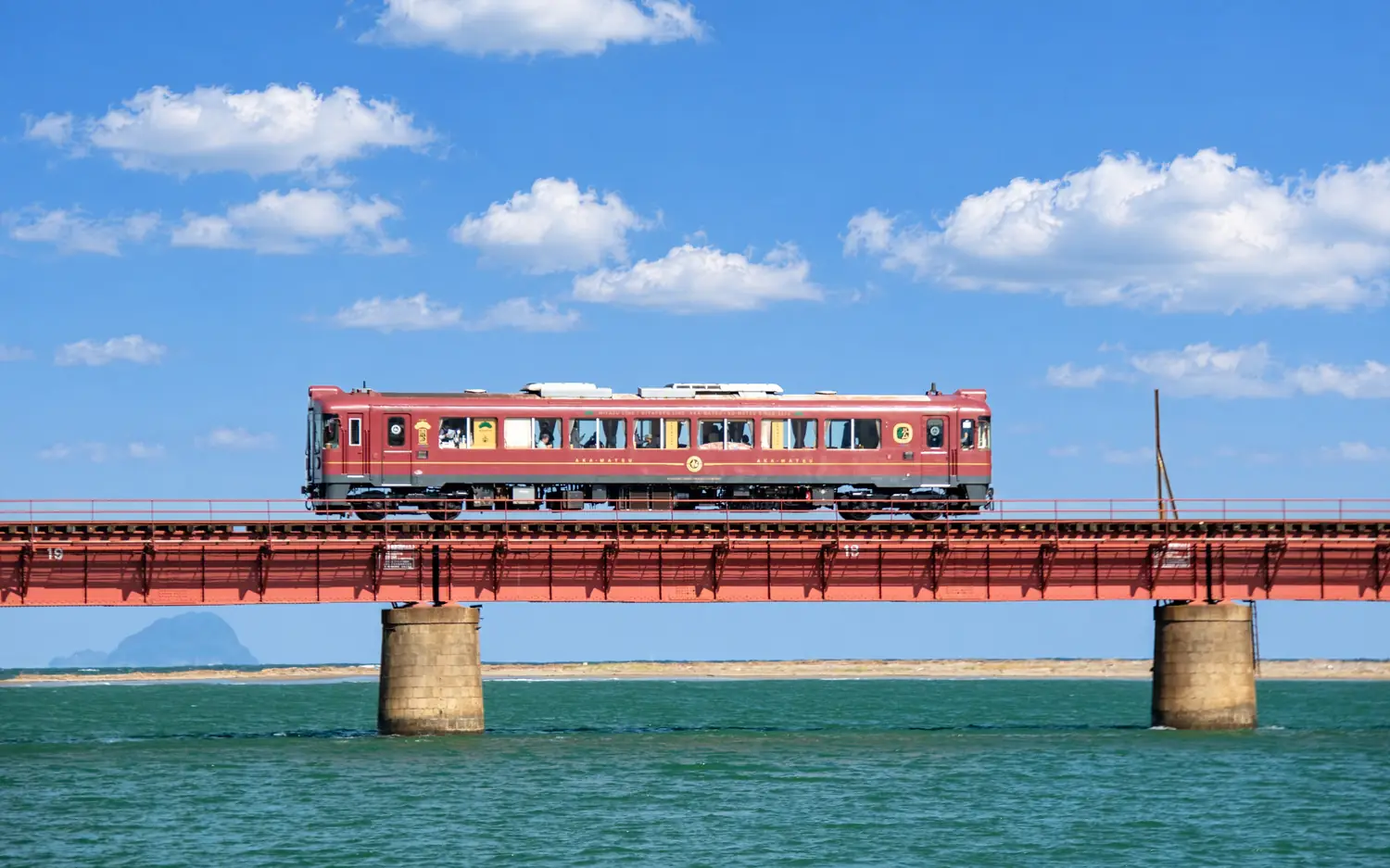 The Tango Akamatsu train on a bridge over the water