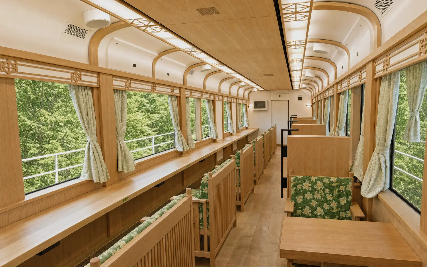 Window-facing counter seats inside the GRAN Tenku train with fresh green outside